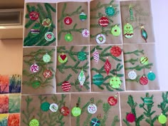 christmas ornaments are displayed on brown paper with green and red decorations hanging from the tree