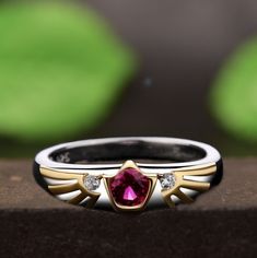 a close up of a ring with a red stone