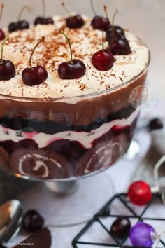 a dessert dish with cherries and whipped cream on the top is ready to be eaten