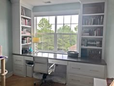 a home office with bookshelves, desk and cat tree