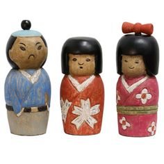 three small wooden dolls are standing next to each other