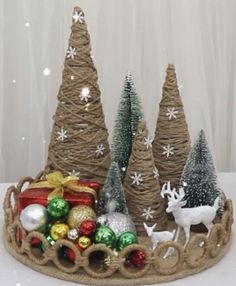 christmas trees and ornaments in a basket on a table