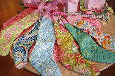 a pile of colorful scarves sitting on top of a table next to a pink christmas tree