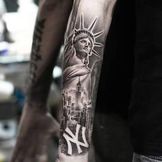 a man's arm with a statue of liberty tattoo on it