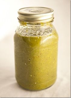 a jar filled with green liquid sitting on top of a table