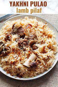 a white plate topped with rice and meat