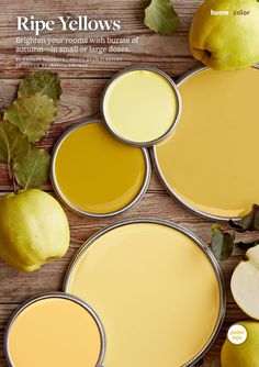 some yellow paint is on the table with apples and leaves