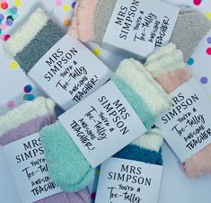 six pairs of mittens with different sayings on them and confetti scattered around