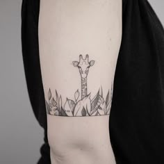 a giraffe tattoo on the left upper arm