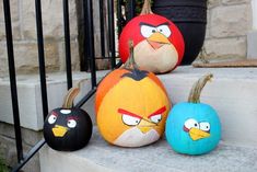 three painted pumpkins with angry birds on them sitting on the steps in front of a house