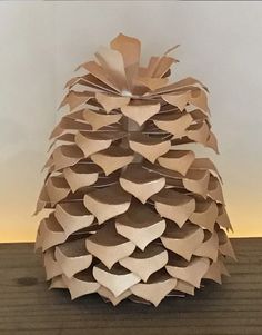 a paper pine cone sitting on top of a wooden table