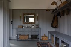 a bathroom with a gray vanity, mirror and hanging lights on the wall above it