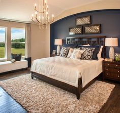 a bedroom with a large bed and chandelier hanging from it's ceiling