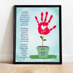 a handprinted poster with a plant in it on a wooden floor next to a wall