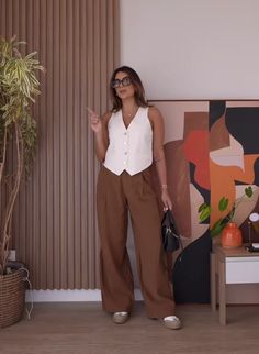 a woman is standing in front of a painting and holding her hand up to the side