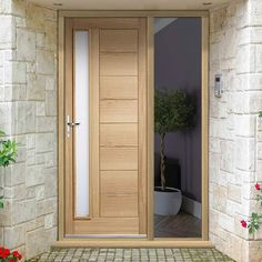 an open wooden door in front of a white brick building with potted plants on the side