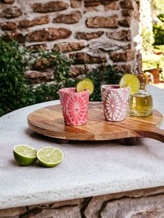 three shot glasses on a tray with limes