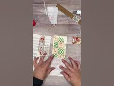 two hands reaching for playing cards on a table with papers and glues around them