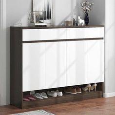 a white cabinet with shoes on it in a room