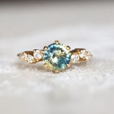 a blue and white diamond ring sitting on top of a table