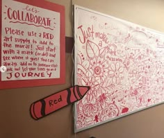 two red crayons are hanging on the wall next to a bulletin board with writing