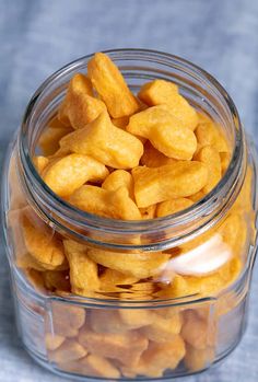 a glass jar filled with cheetos sitting on top of a blue table cloth