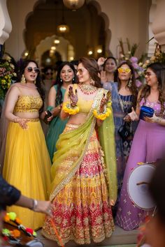 a group of women standing next to each other in front of a crowd at a wedding