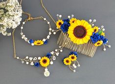 sunflowers and blue flowers are attached to a hair comb with pearls on it