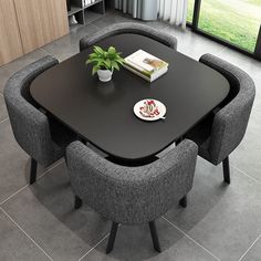 a black table with grey chairs around it and a book on the plate next to it