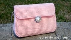 a pink purse sitting on top of a rock