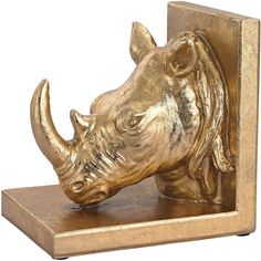 a gold rhino head mounted on a wooden block with a metal base and brass finish