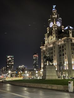 a clock tower in the middle of a city at night