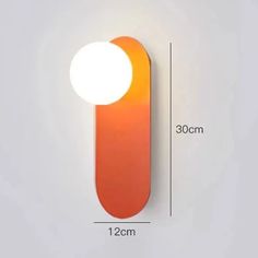 an orange and white wall light on the side of a building with measurements for it