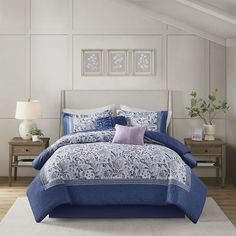 a bed with blue and white comforters in a room