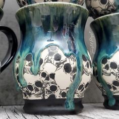 two vases with skulls painted on them sitting next to each other