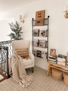 a living room with a chair and bookshelf next to a stair case filled with books