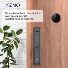 an electronic door lock on a wooden door next to a potted plant and brick wall