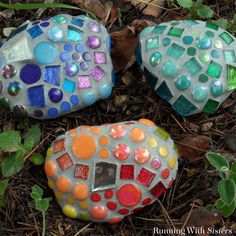 three colorful rocks sitting in the grass