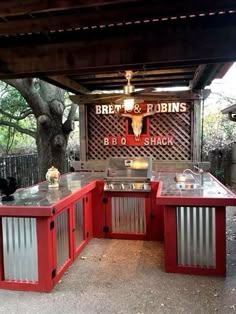 an outdoor bbq with grills and tables under a shade structure that reads great & robin's bbq shack