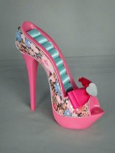 a pink high heeled shoe with a bow on the side and flowers all over it