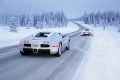 a white sports car driving down a snowy road