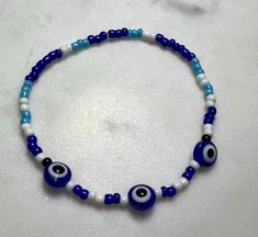 a blue and white beaded bracelet with evil eyes