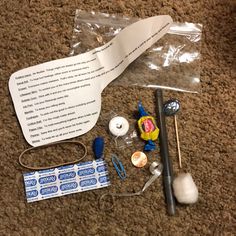 the contents of a sewing kit are laid out on the floor