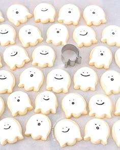 some cookies are decorated with white icing and have faces drawn on them to look like ghostes