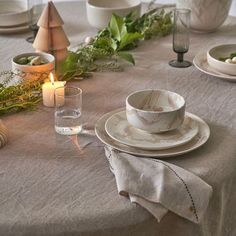 the table is set with dishes and candles