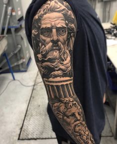 a man's arm with tattoos on it and an image of a bearded man