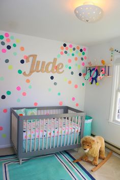 a baby's room decorated with polka dot wallpaper