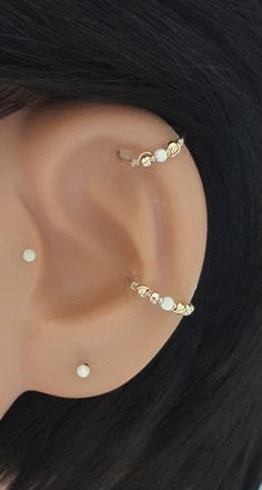 a close up view of a fake ear with pearls and gold beads on the side