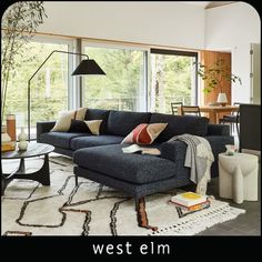 a living room filled with furniture and a large window covered in lots of natural light