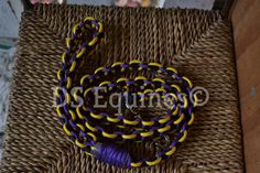 a purple and yellow lanyard on a wicker table